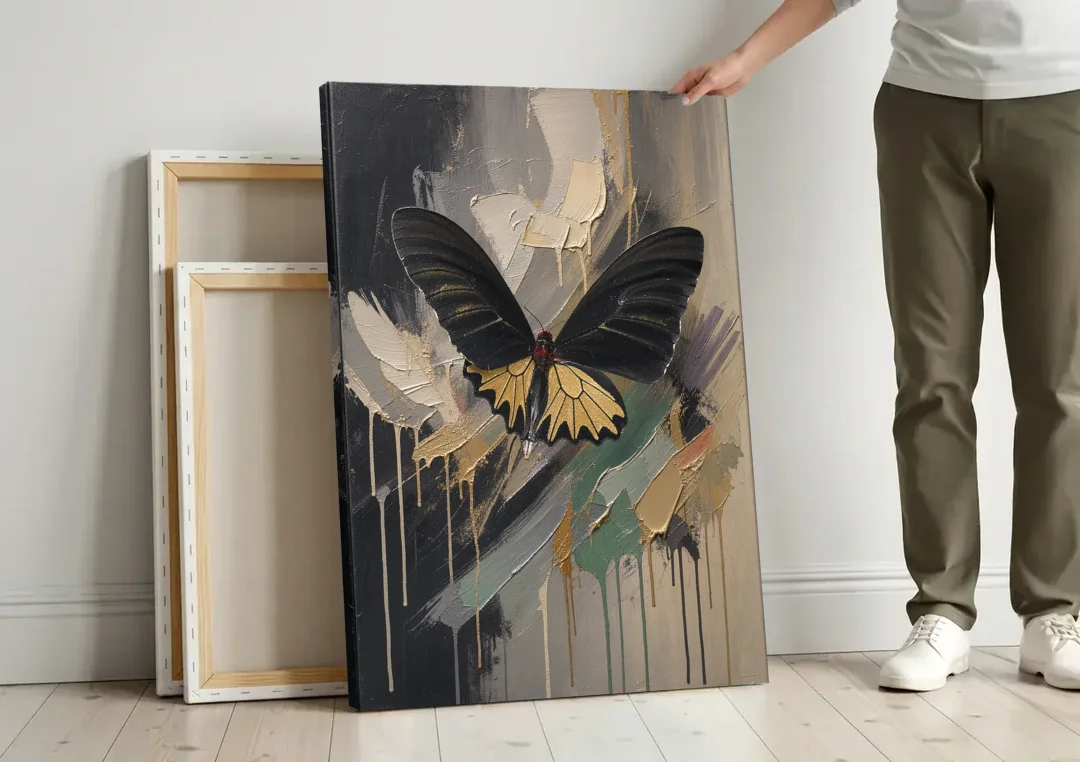 Gold Butterfly Wall Art of a Birdwing on Charcoal canvas wall art leaning against a wall next to blank canvases