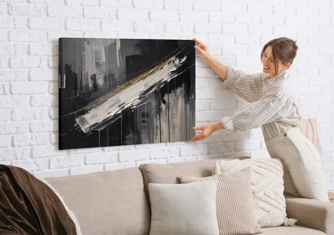 Gold-Edged White Sweep in Black and White canvas wall art being hung on a white brick wall above a sofa