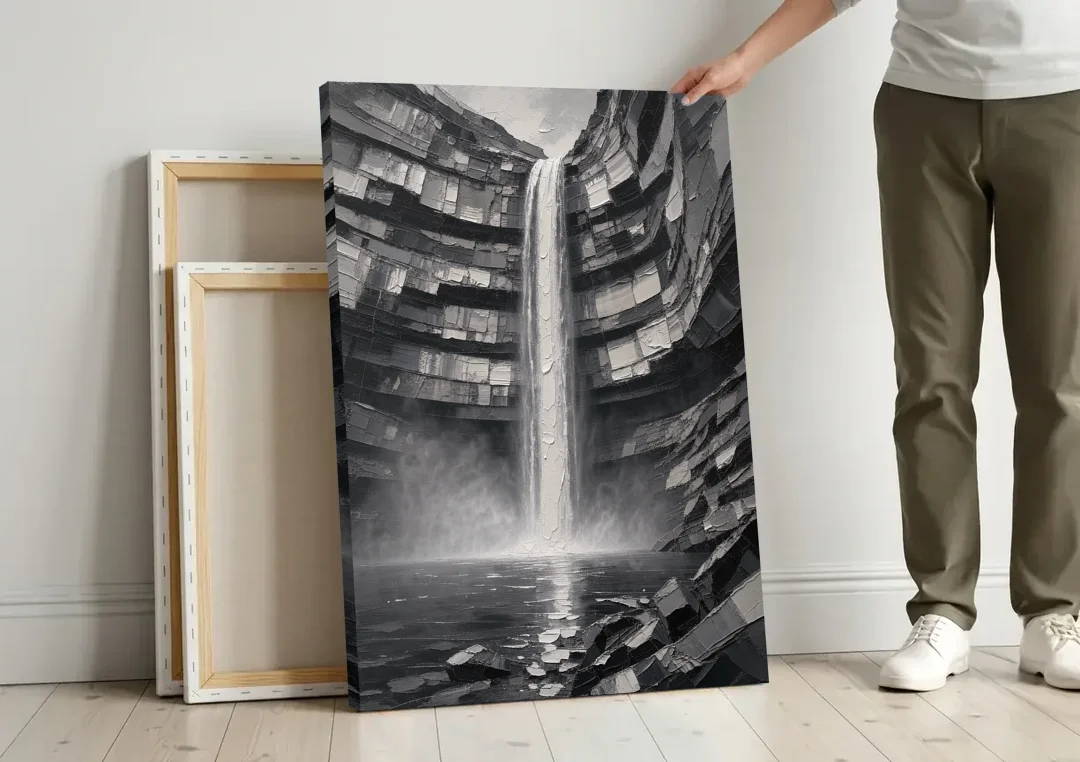 Grayscale Wall Art of a Canyon Waterfall canvas wall art leaning against a wall next to blank canvases