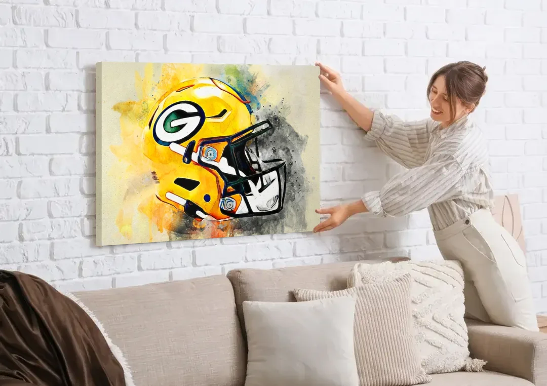 Green Bay Packers Yellow Helmet Expressive Watercolor canvas wall art being hung on a white brick wall above a sofa