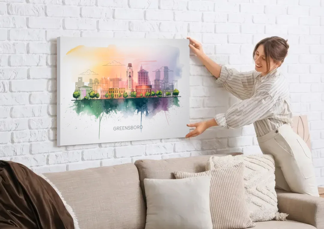 Greensboro Skyline Sunset canvas wall art being hung on a white brick wall above a sofa