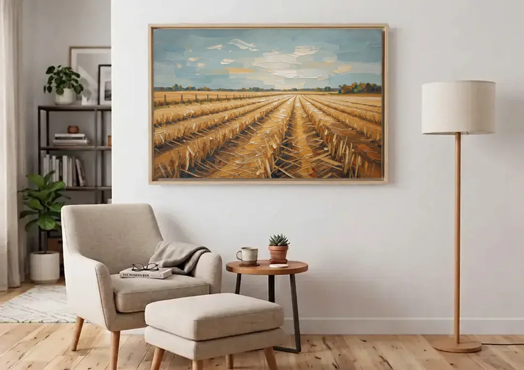 Harvested Stubble Field Rows Under a Pale Sky canvas wall art above an armchair in a bright living room