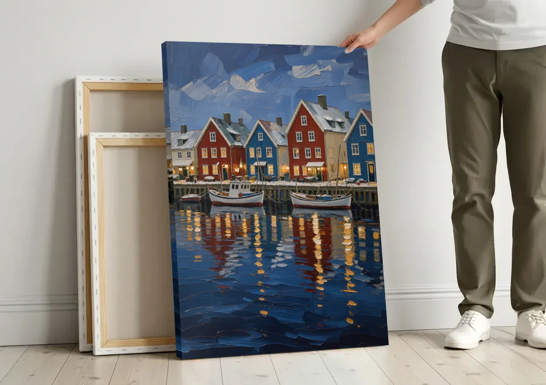 Holiday Snowy Harbor Fishing Village canvas wall art leaning against a wall next to blank canvases