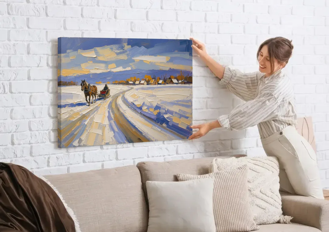 Horse Drawn Sleigh Painting Toward the Village canvas wall art being hung on a white brick wall above a sofa