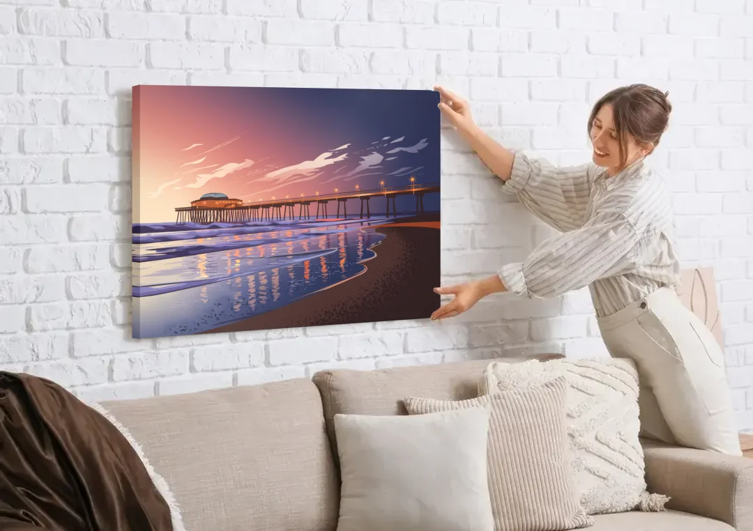 Huntington Beach Pier At Twilight canvas wall art being hung on a white brick wall above a sofa