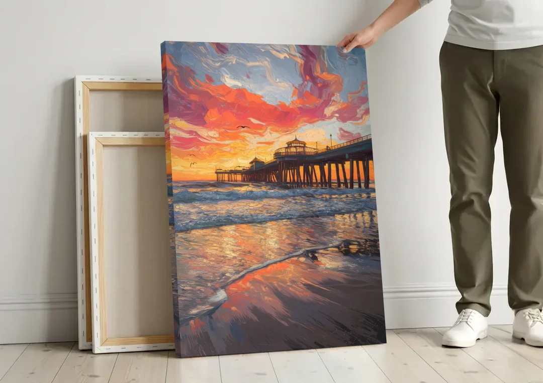 Huntington Beach Pier Sunset canvas wall art leaning against a wall next to blank canvases