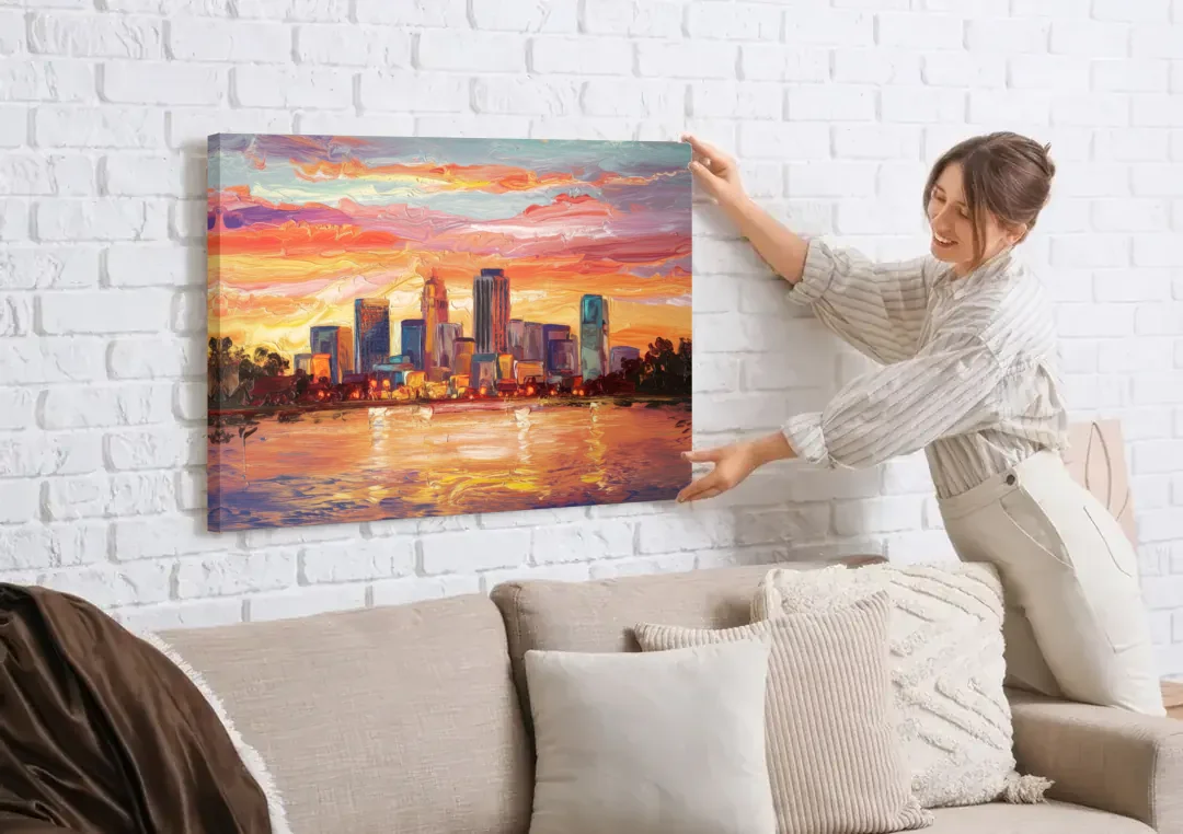 Huntsville Skyline At Sunset canvas wall art being hung on a white brick wall above a sofa