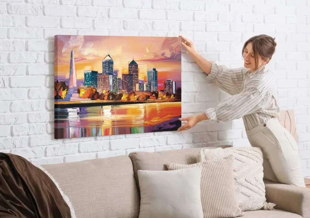 Indianapolis Skyline At Sunset canvas wall art being hung on a white brick wall above a sofa