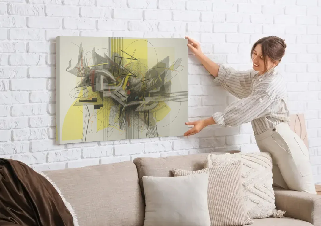 Intricate Layered Dance Yellow and Grey Abstract canvas wall art being hung on a white brick wall above a sofa
