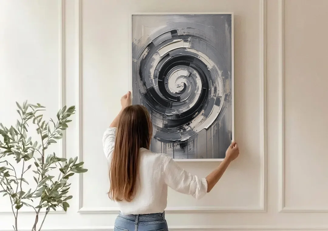 Modern Black and White Inward Spiral canvas wall art being hung on a paneled wall