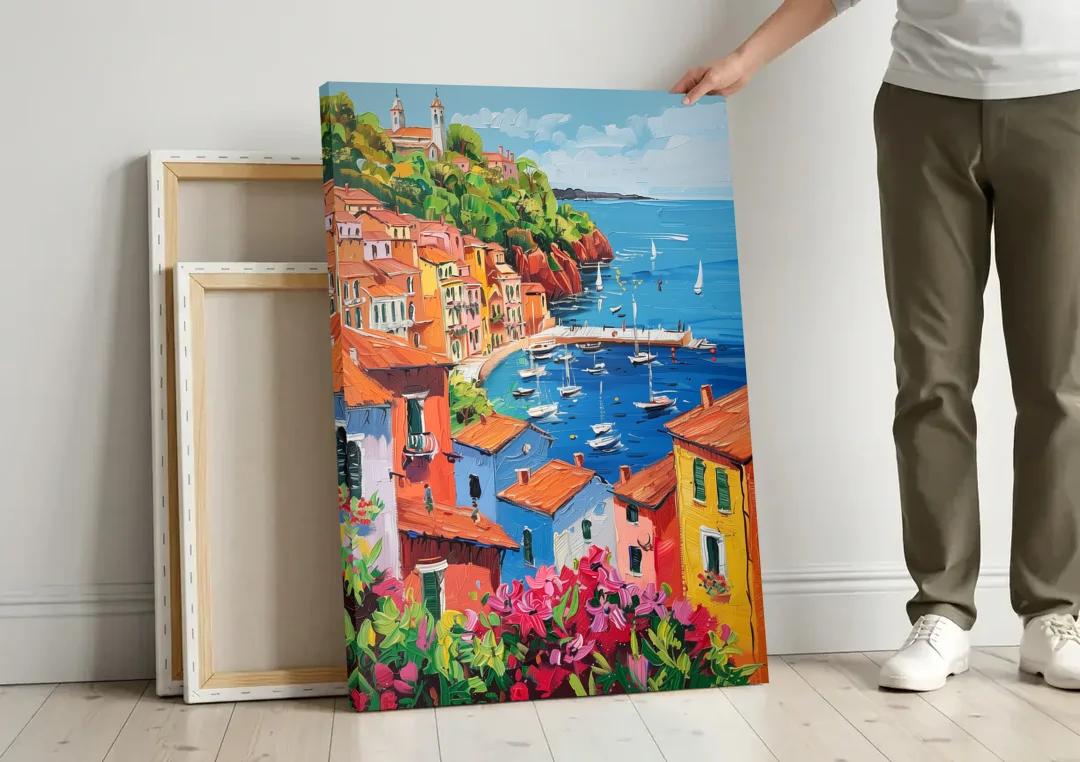 Italian Riviera Art with a Sailboat Harbor canvas wall art leaning against a wall next to blank canvases