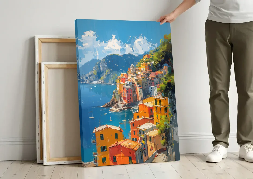 Italian Riviera Painting of a Harbor Village canvas wall art leaning against a wall next to blank canvases