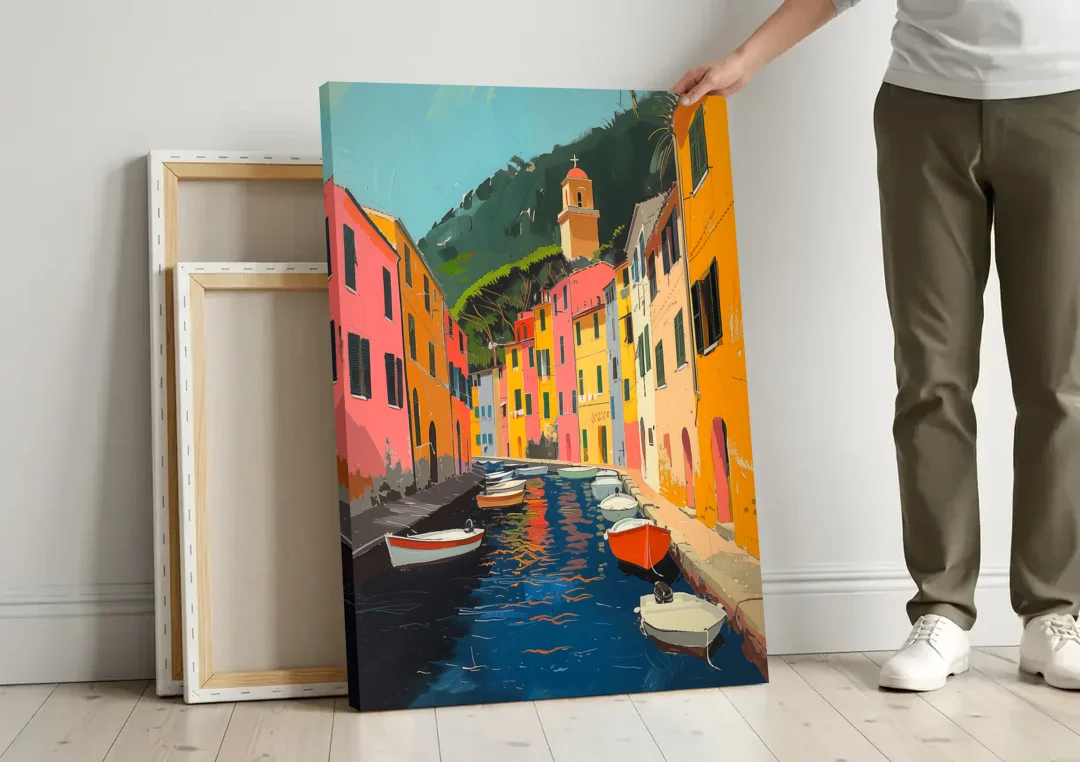 Italy Painting of a Canal with Boats canvas wall art leaning against a wall next to blank canvases