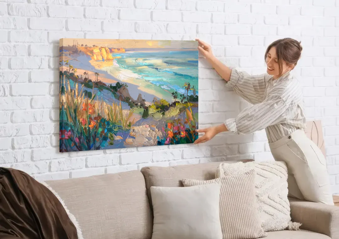 La Jolla Pacific Blues canvas wall art being hung on a white brick wall above a sofa