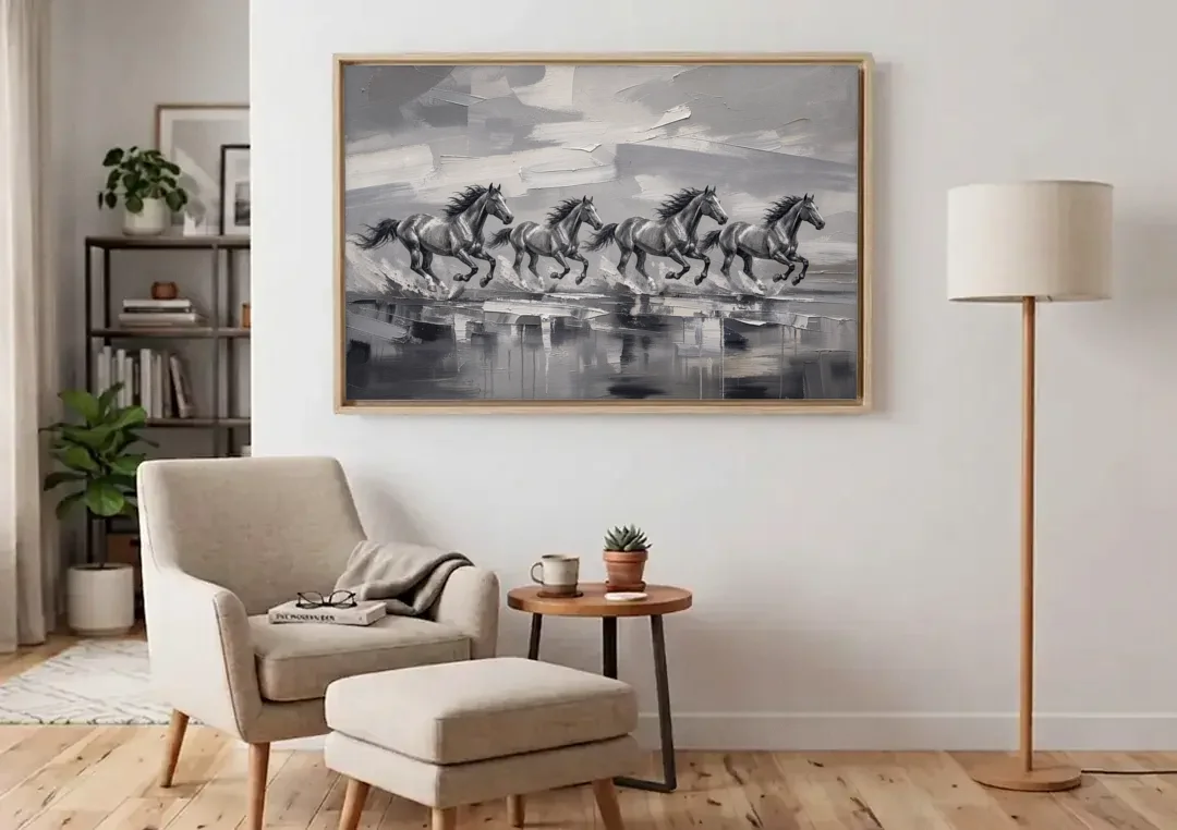 Large Black and White Scene of Four Galloping Horses canvas wall art above an armchair in a bright living room