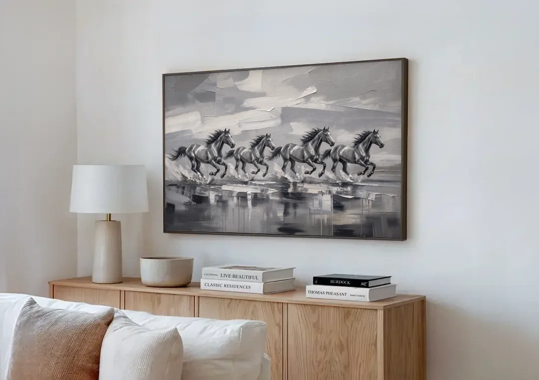 Large Black and White Scene of Four Galloping Horses canvas wall art above a wooden sideboard next to a sofa