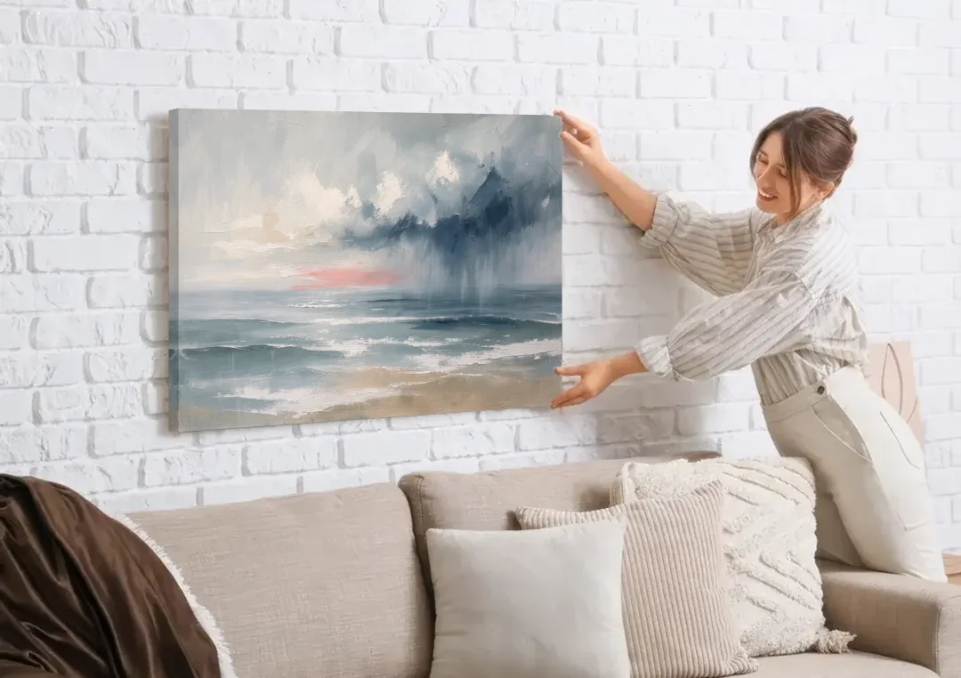 Large Coastal Wall Art of a Distant Squall canvas wall art being hung on a white brick wall above a sofa