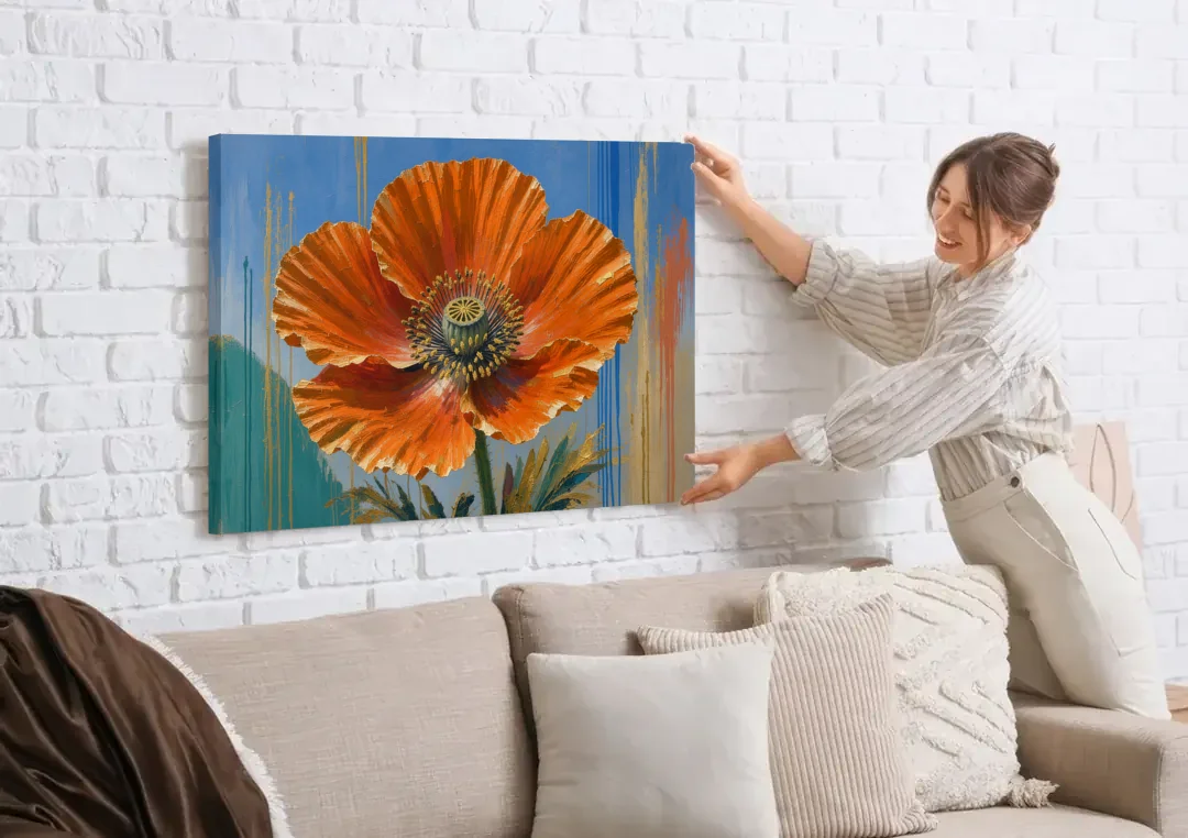 Large Floral Canvas Wall Art of an Orange Poppy canvas wall art being hung on a white brick wall above a sofa