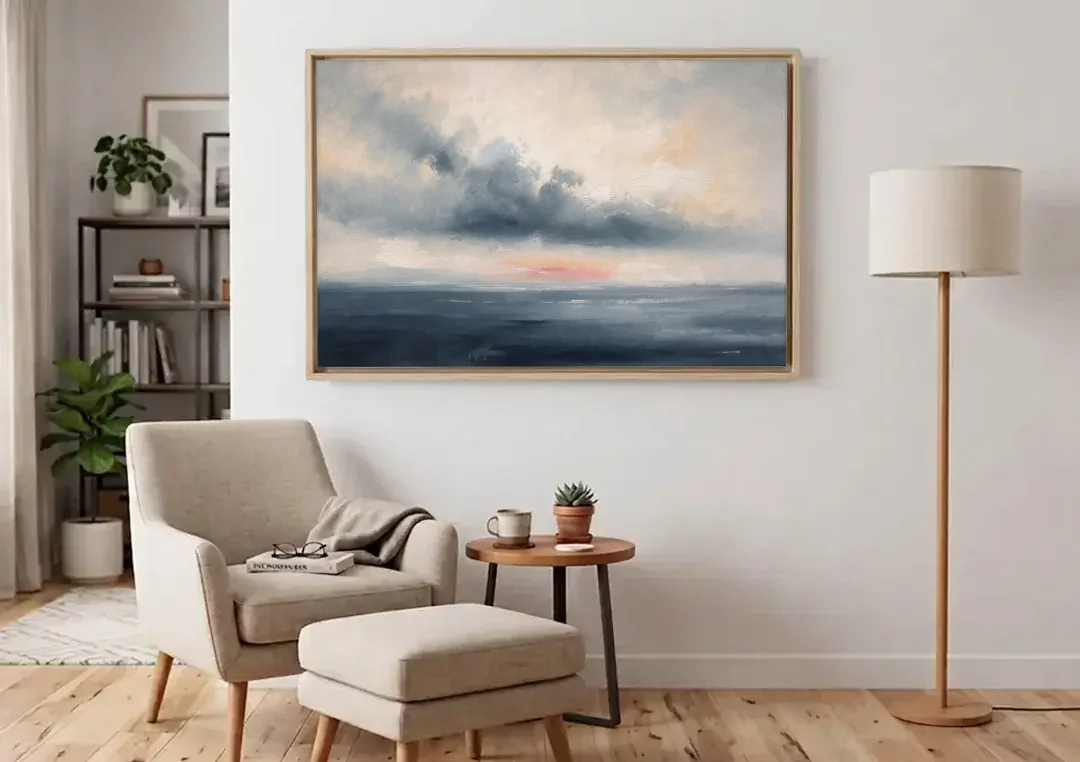 Long Horizontal Cloud Bank Over a Calm Sea canvas wall art above an armchair in a bright living room