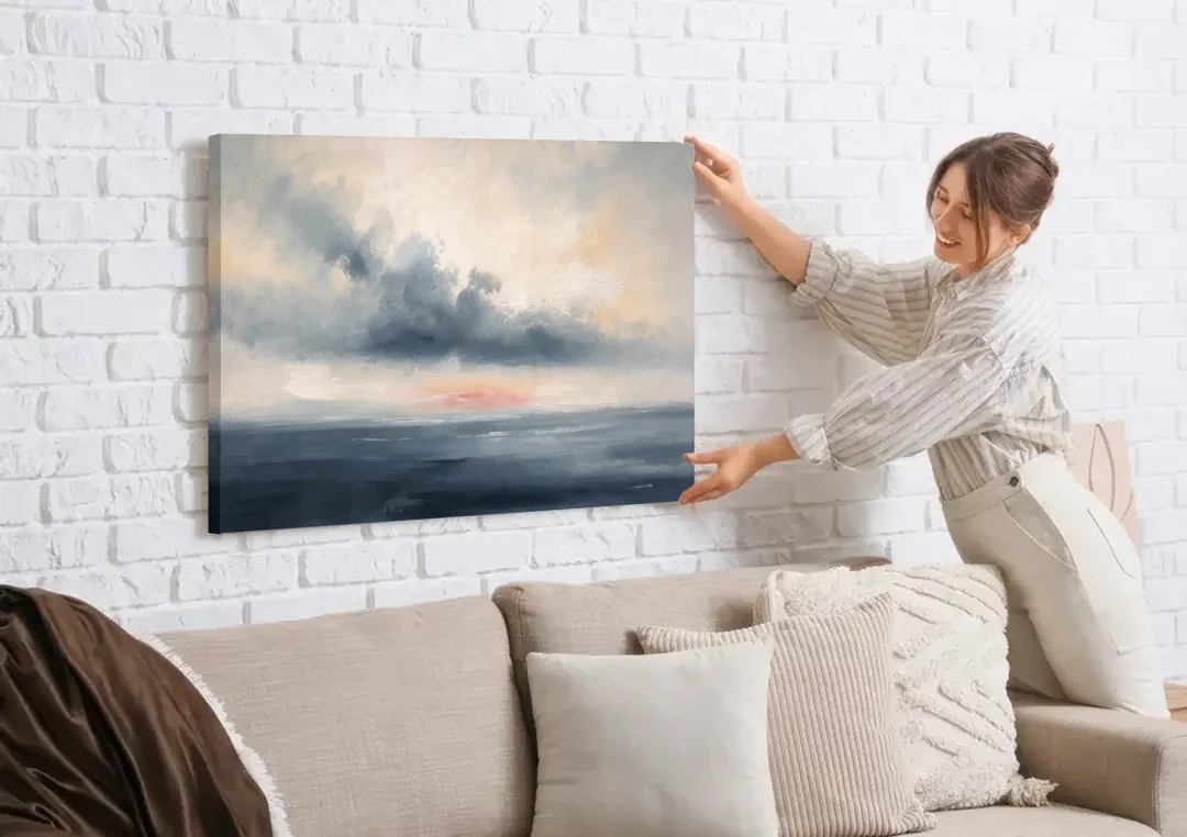 Long Horizontal Cloud Bank Over a Calm Sea canvas wall art being hung on a white brick wall above a sofa