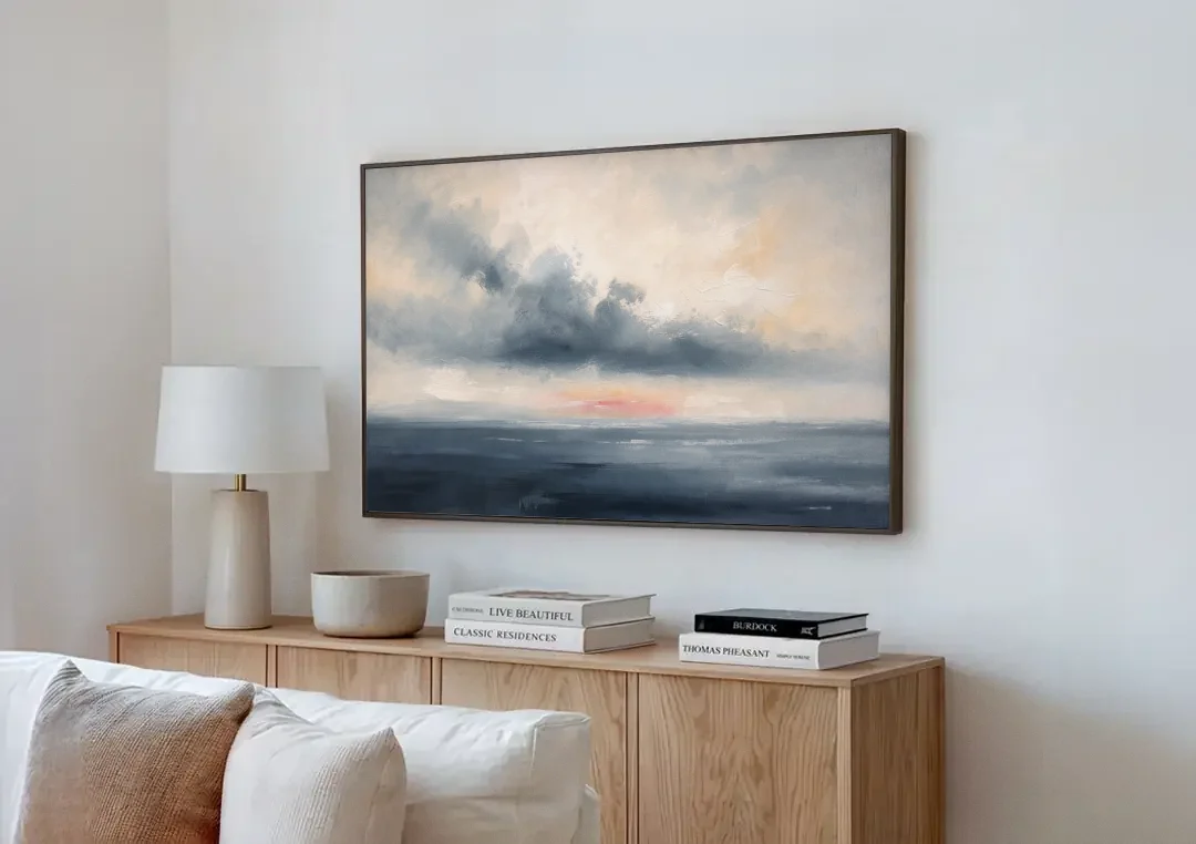 Long Horizontal Cloud Bank Over a Calm Sea canvas wall art above a wooden sideboard next to a sofa