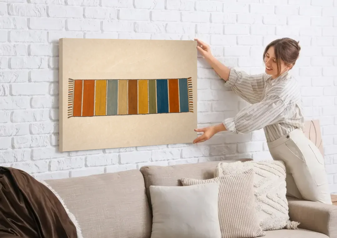 Long Narrow Wall Art of a Painted Rug Runner canvas wall art being hung on a white brick wall above a sofa