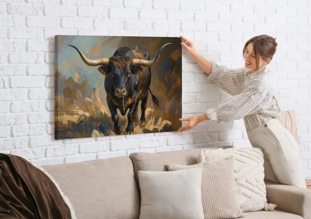 Longhorn Painting of a Black Steer Striding Forward canvas wall art being hung on a white brick wall above a sofa
