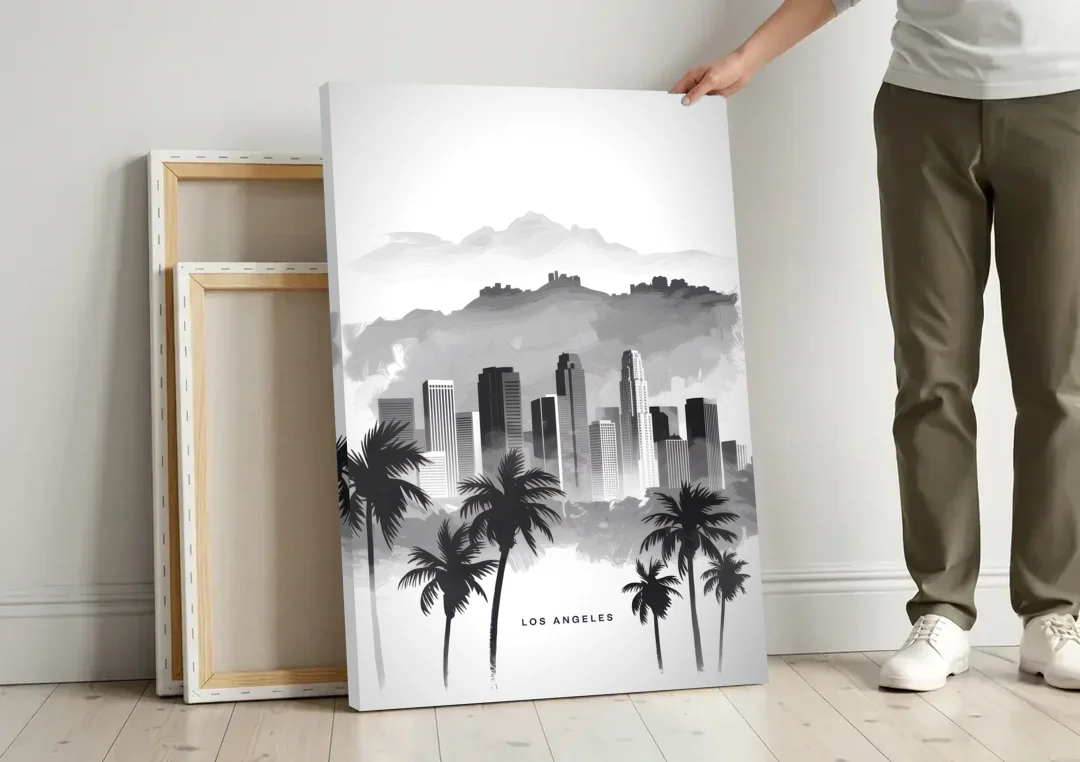 Los Angeles Black and White Cityscape canvas wall art leaning against a wall next to blank canvases