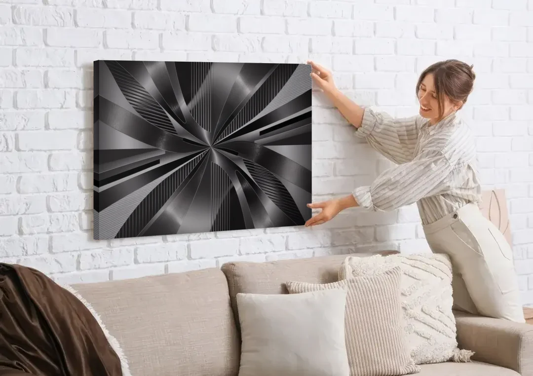 Luxurious Fluidity Black and Grey Abstract canvas wall art being hung on a white brick wall above a sofa