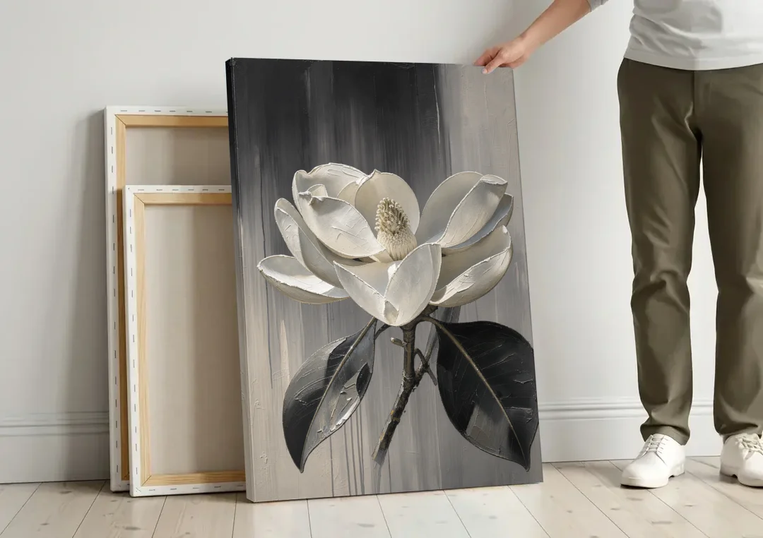 Magnolia Canvas Art with a Single White Bloom canvas wall art leaning against a wall next to blank canvases