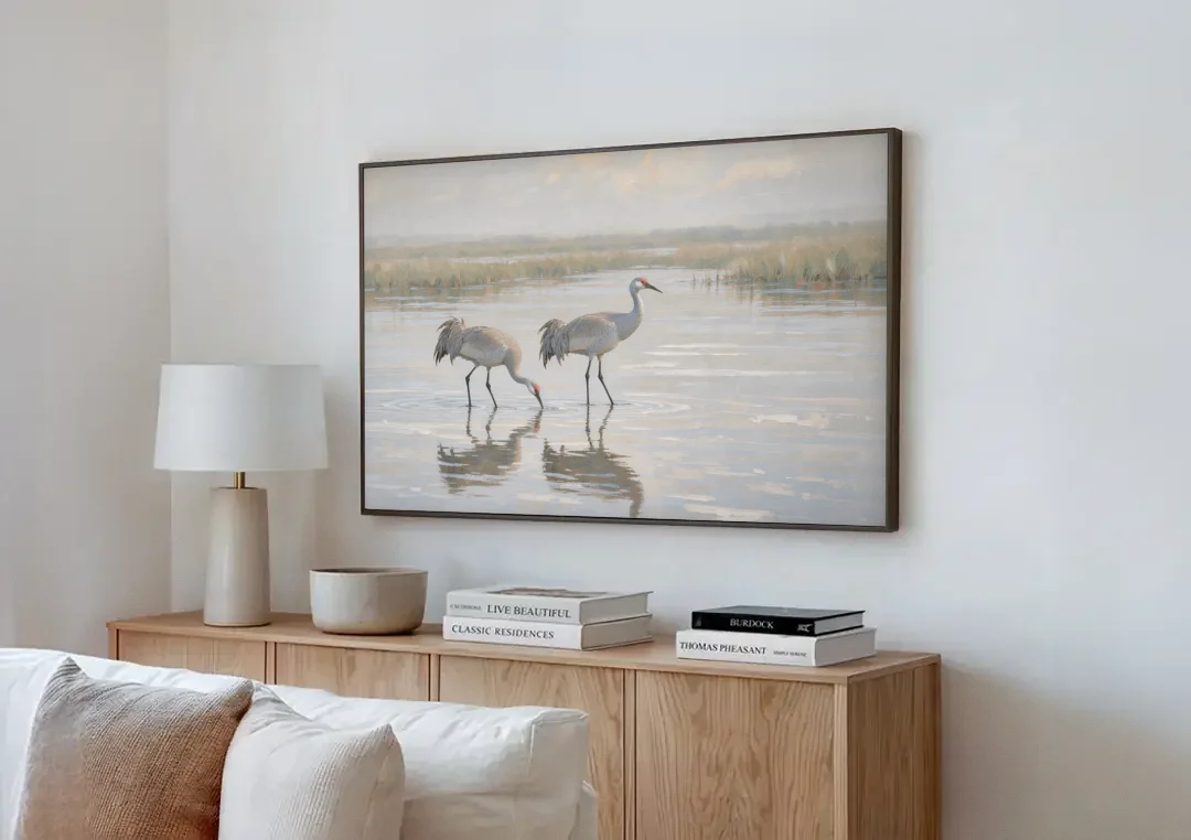 Marsh Landscape Painting with Two Sandhill Cranes canvas wall art above a wooden sideboard next to a sofa