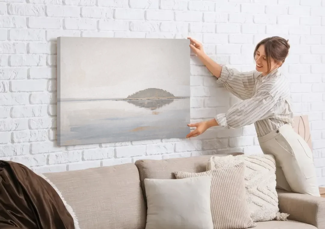Matching Wall Art Set of 2 Mirrored Island canvas wall art being hung on a white brick wall above a sofa