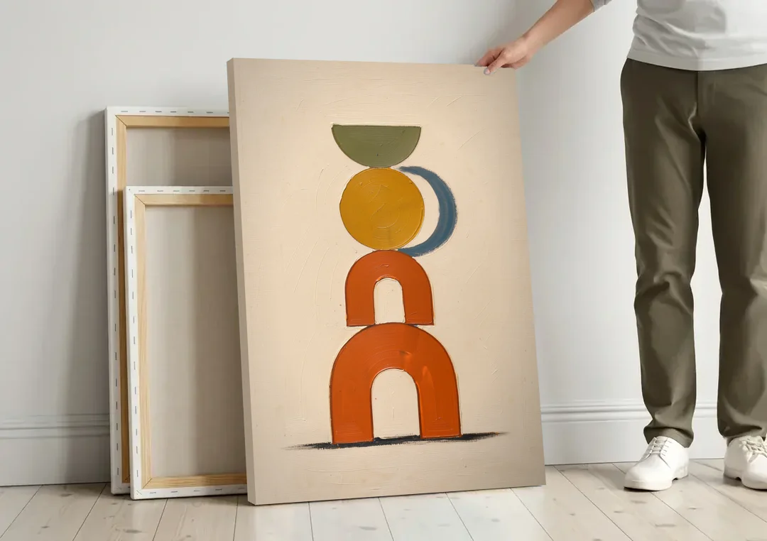 Mid Century Boho Wall Art of Stacked Clay Arches canvas wall art leaning against a wall next to blank canvases