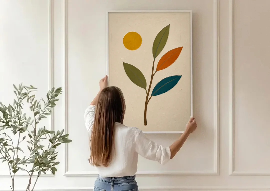 Mid Century Modern Paintings of Three Leaves and Sun canvas wall art being hung on a paneled wall