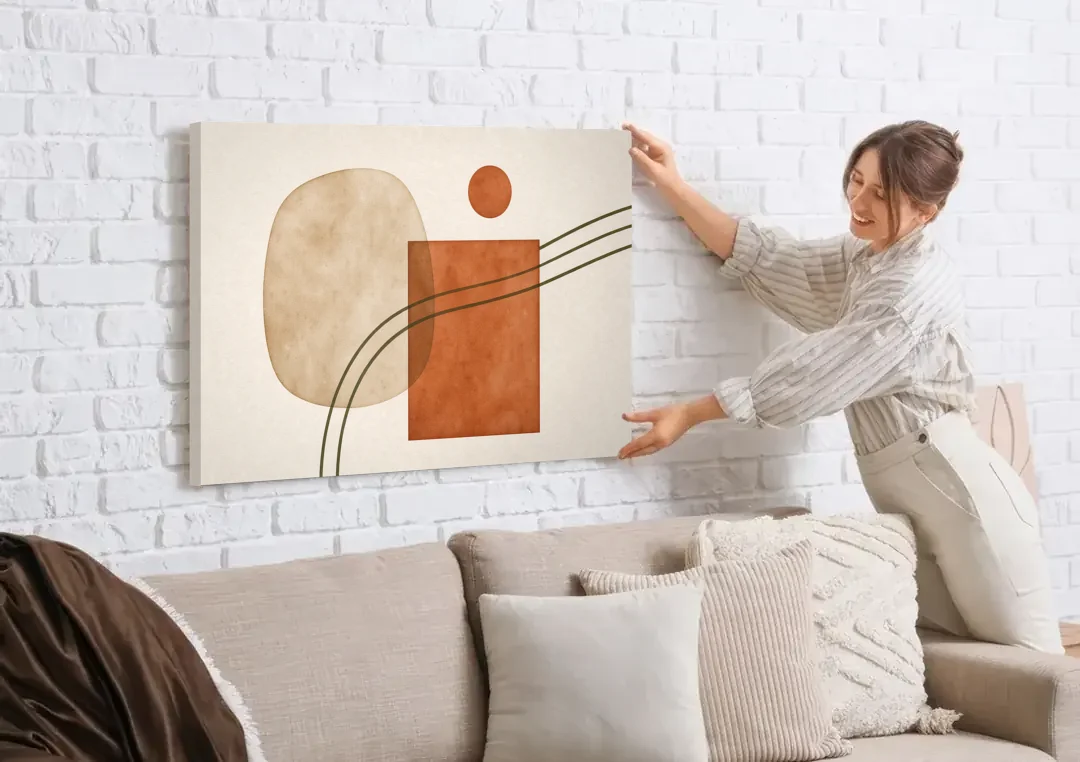 Mid Century Modern Wall Decor Pebble and Olive Arcs canvas wall art being hung on a white brick wall above a sofa