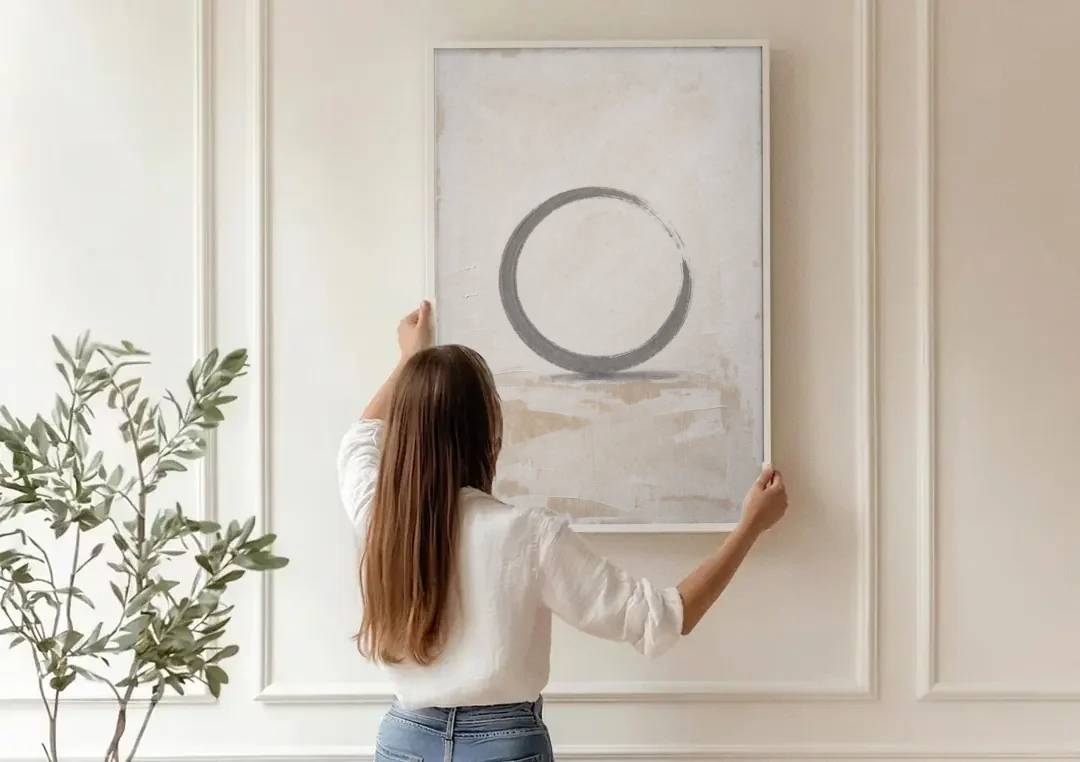 Minimal Wall Art of an Open Graphite Circle canvas wall art being hung on a paneled wall