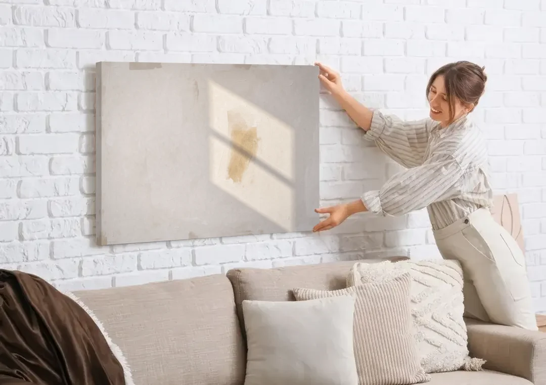 Minimalist Abstract Painting of Window Light canvas wall art being hung on a white brick wall above a sofa
