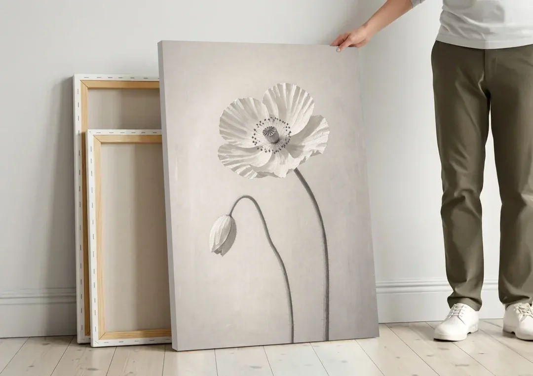 Minimalist Flower Wall Art of a Poppy and Bud canvas wall art leaning against a wall next to blank canvases