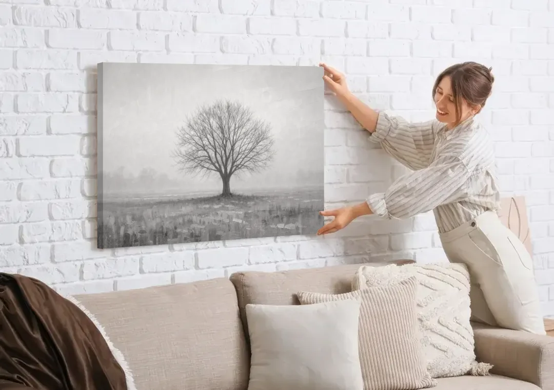 Minimalist Landscape Painting of a Lone Tree in Fog canvas wall art being hung on a white brick wall above a sofa