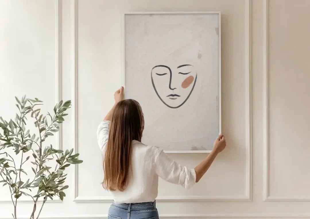 Minimalist Line Art Face with Terracotta Blush canvas wall art being hung on a paneled wall