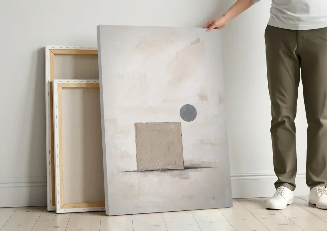 Minimalist Wall Decor with Driftwood Square and Slate Circle canvas wall art leaning against a wall next to blank canvases