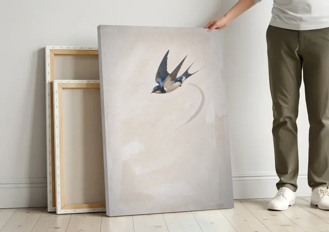 Modern Bird Painting of a Diving Barn Swallow canvas wall art leaning against a wall next to blank canvases