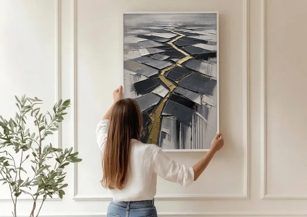 Modern Black White and Gold Abstract Fissure canvas wall art being hung on a paneled wall