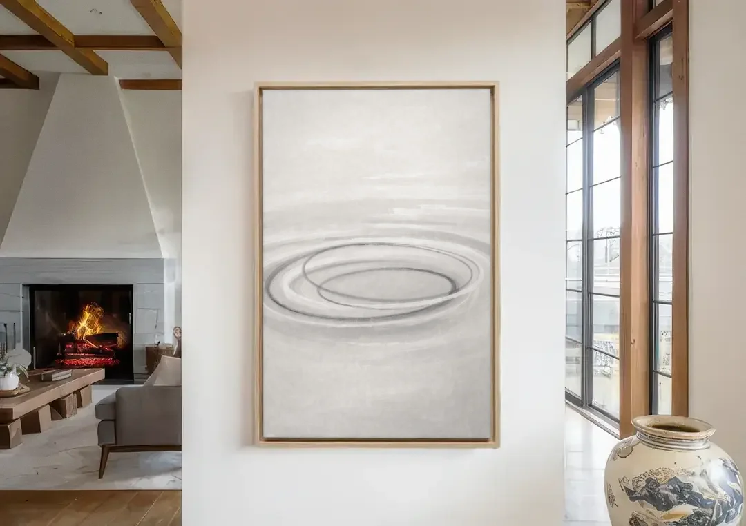 Modern Black White and Grey Abstract Ripple Rings canvas wall art in a living room with a fireplace