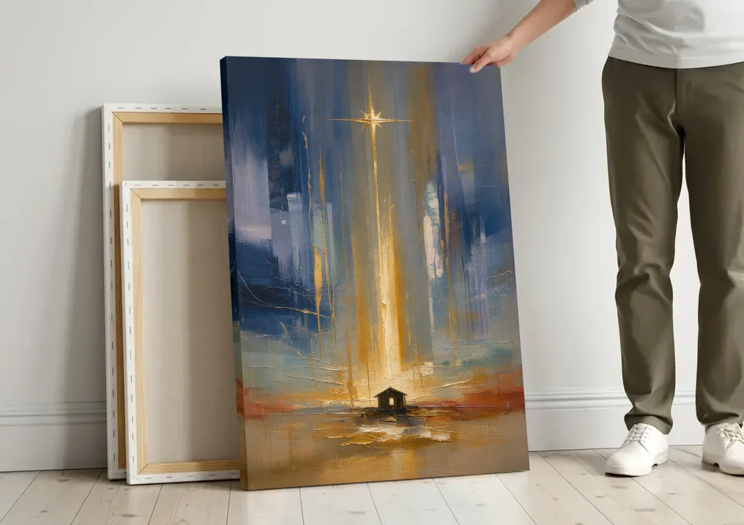 Modern Nativity Painting with Falling Gold Light canvas wall art leaning against a wall next to blank canvases