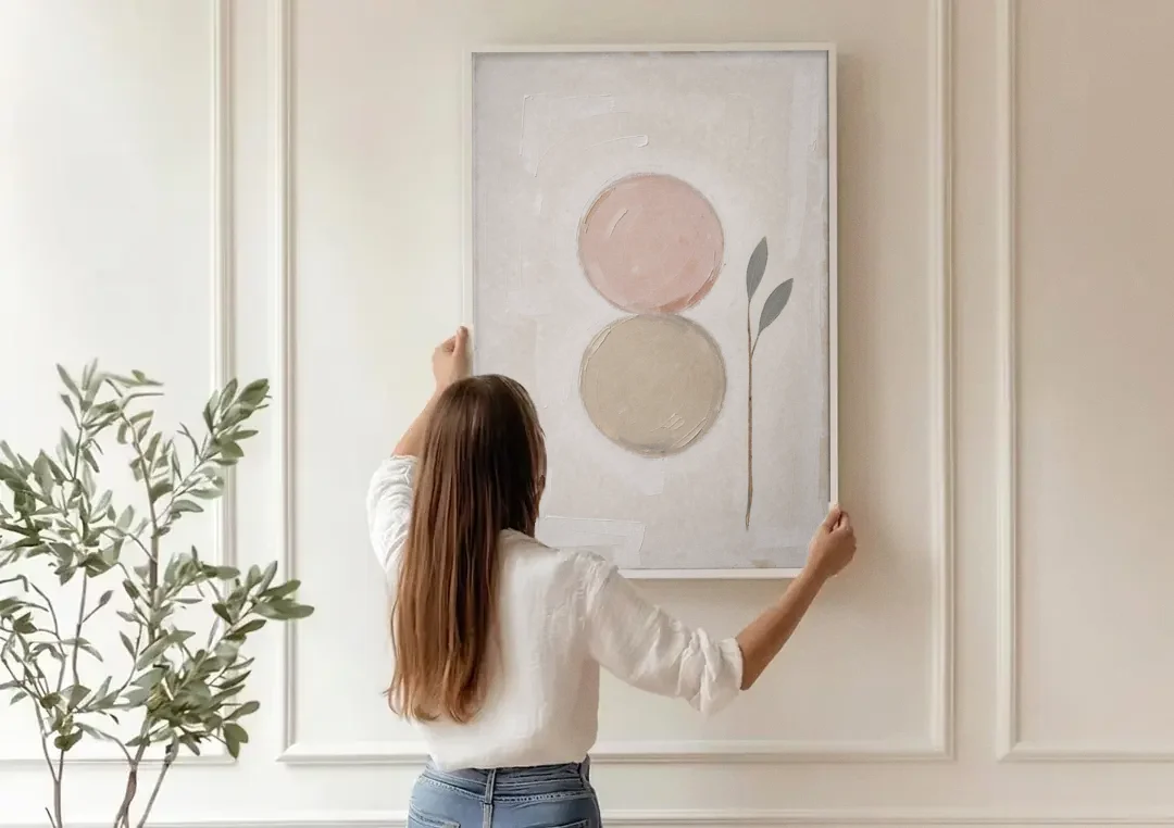 Modern Organic Wall Art with Blush and Clay Circles canvas wall art being hung on a paneled wall