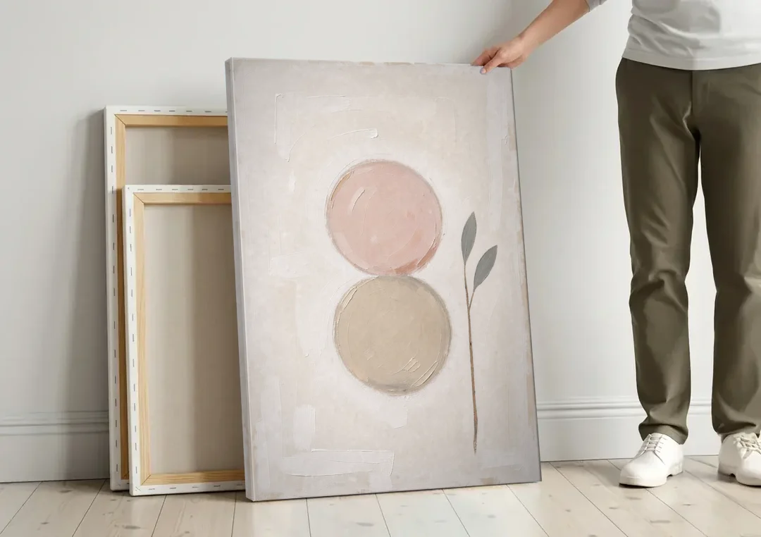 Modern Organic Wall Art with Blush and Clay Circles canvas wall art leaning against a wall next to blank canvases