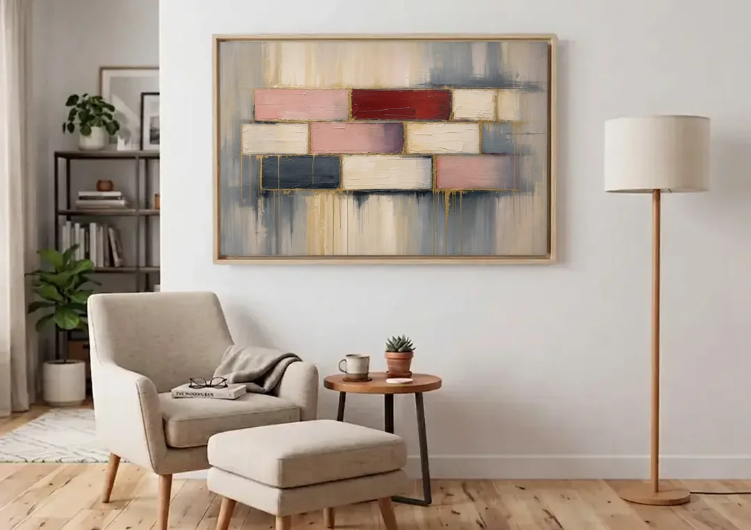 Modern Textured Wall Art of Blush and Crimson Stones canvas wall art above an armchair in a bright living room
