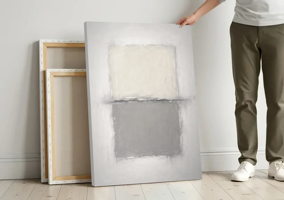 Monochrome Abstract Wall Art with a Charcoal Seam canvas wall art leaning against a wall next to blank canvases