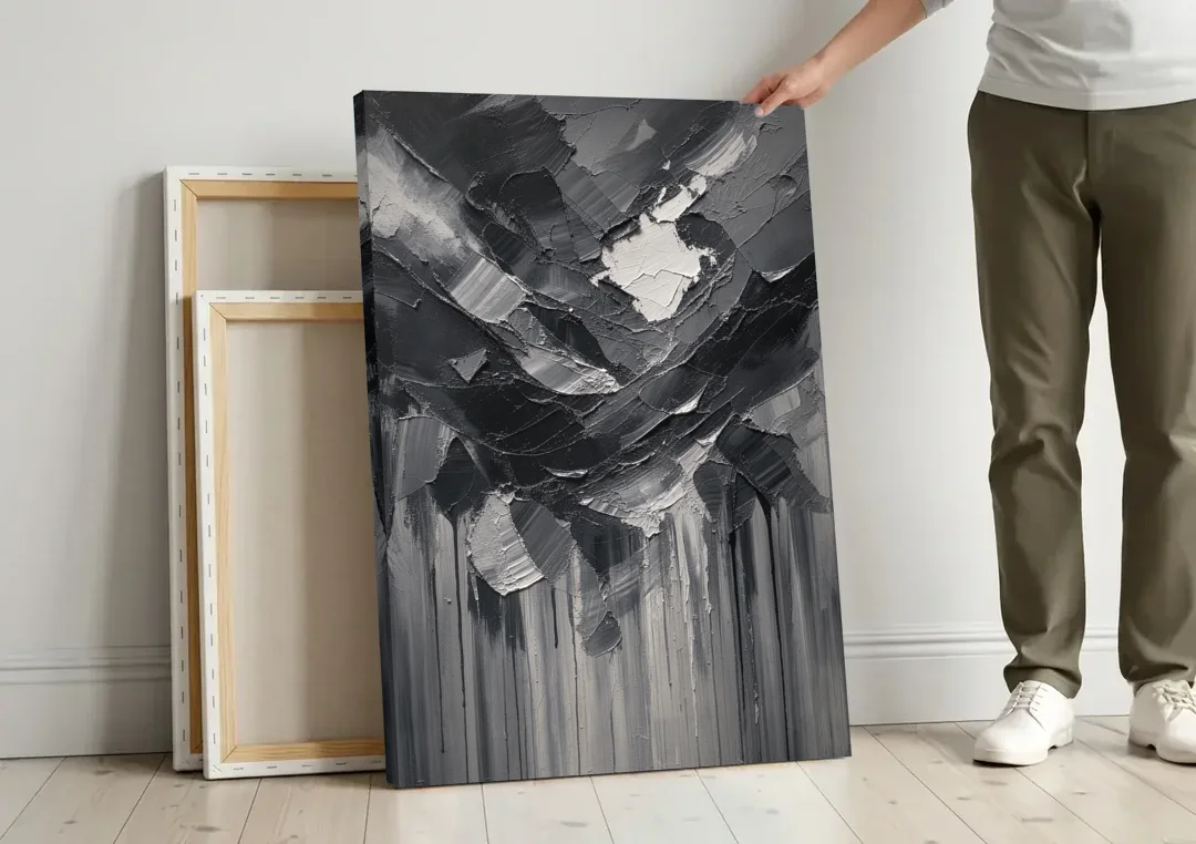 Moody Abstract Storm Tear in Charcoal Impasto canvas wall art leaning against a wall next to blank canvases